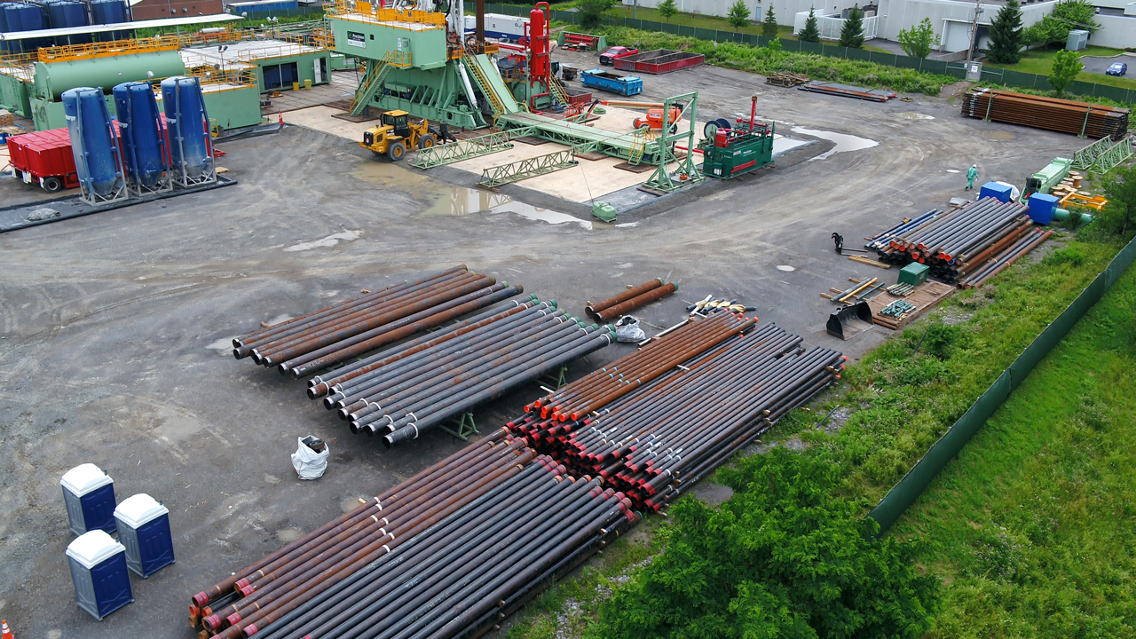 Almost 8,000 feet of steel well casing sits in the lot next to the drill rig, waiting to be installed.