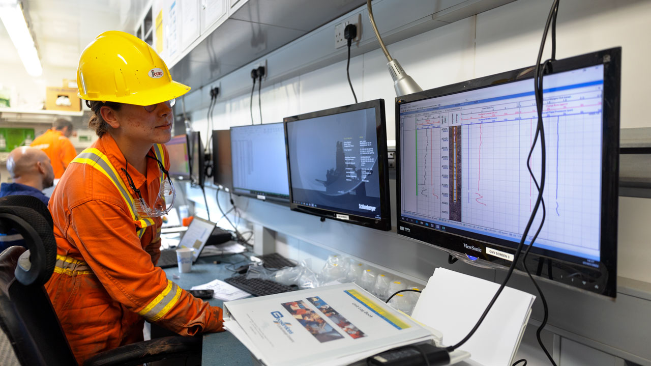 A member of the project team reviews data from the CUBO drilling operation to help track the progress of drilling through the different rock layers. (July 7, 2022)