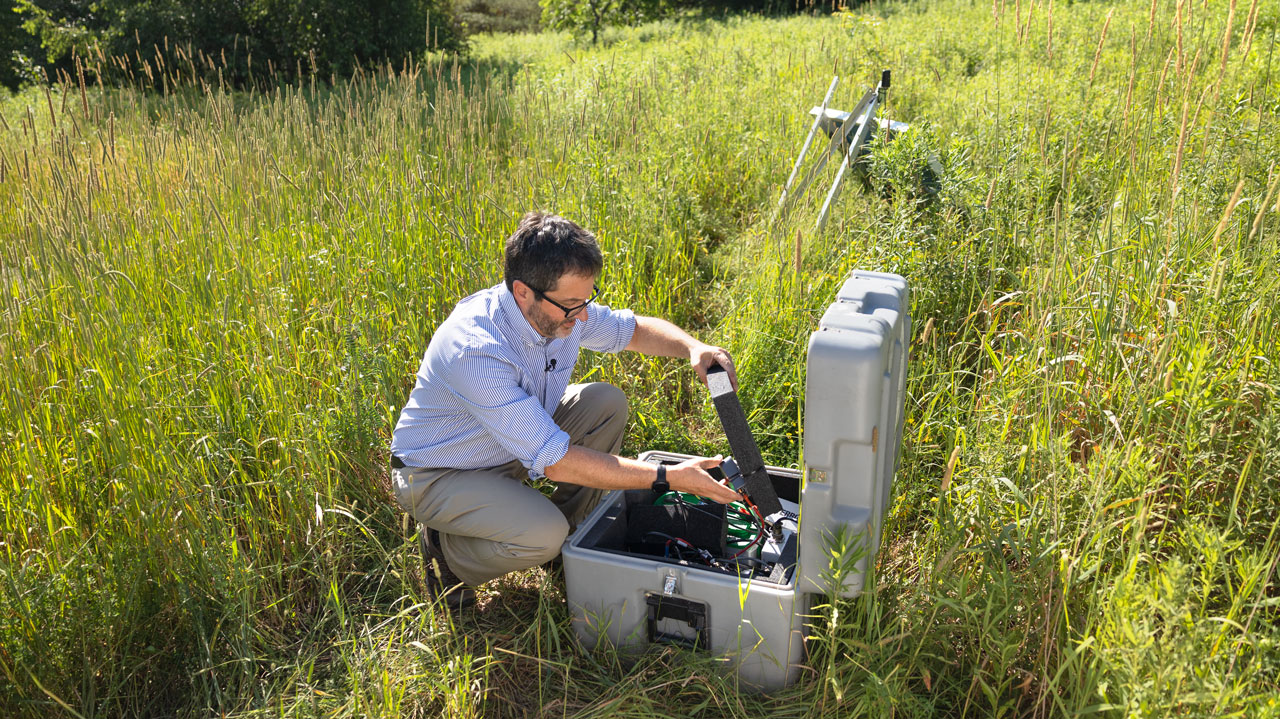 Geoff Abers, Chair, Department of Earth and Atmospheric Sciences, examines seismic monitoring equipment near the borehole site. (July 7, 2022)