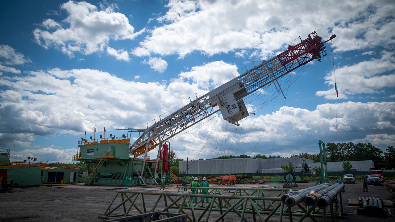 The tower portion of the rig, known as a derrick or mast, is raised on June 17, 2022.